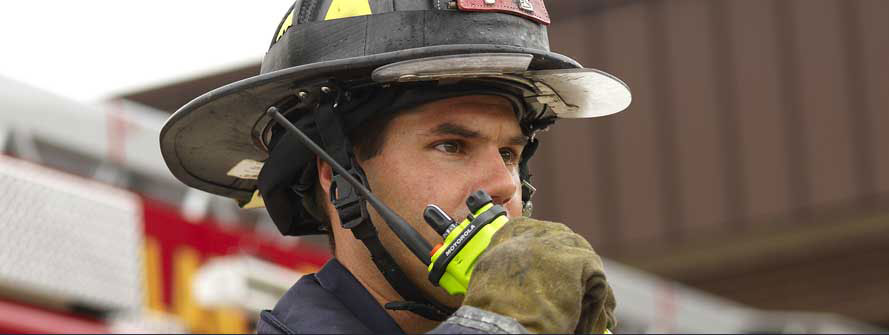 fire fighter holding p25 two way radio